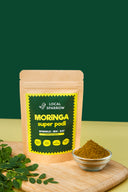 Local Sparrow Moringa Super Podi pouch with a bowl of moringa chutney powder and fresh moringa leaves